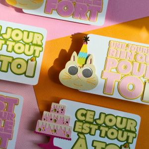 Carte d’anniversaire en papier découpé avec un design de pièce montée, chat et bougie en relief.