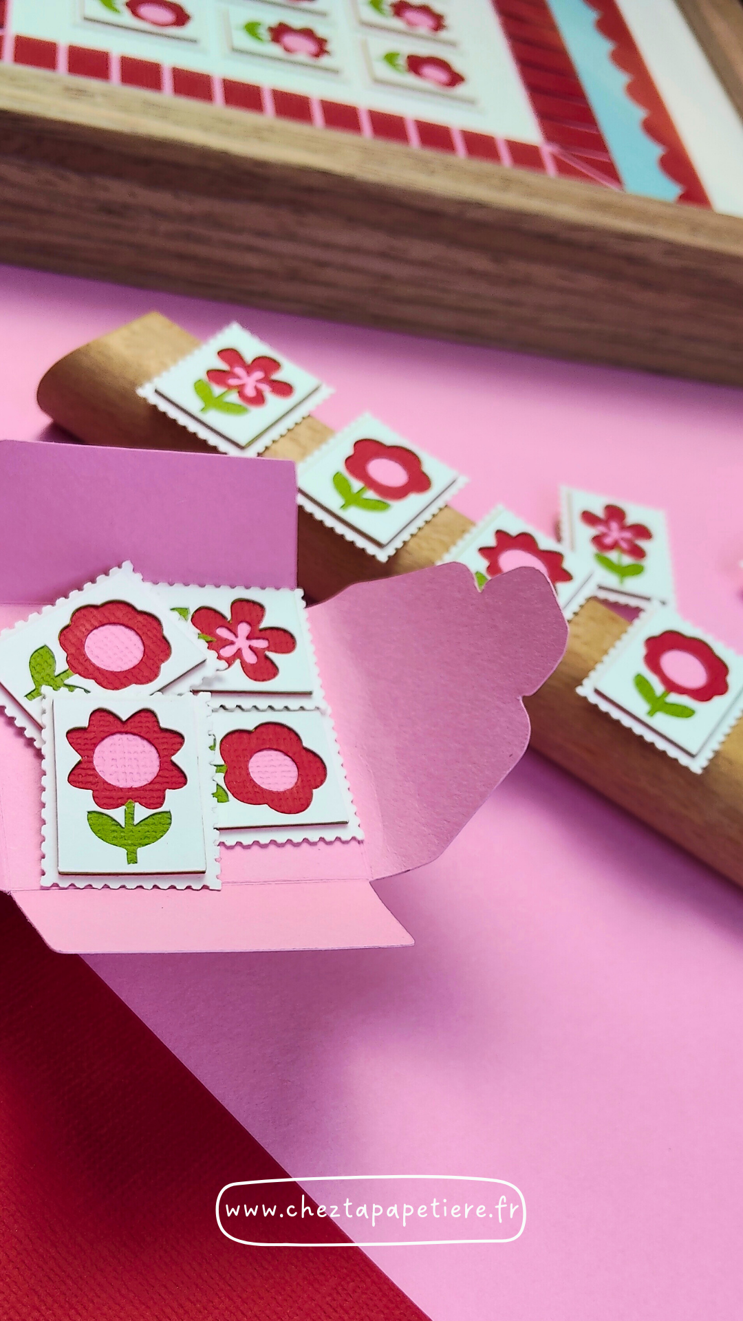 Quatre mini timbres fleurs rouges en papier découpé à la main présentés dans un cadre décoratif