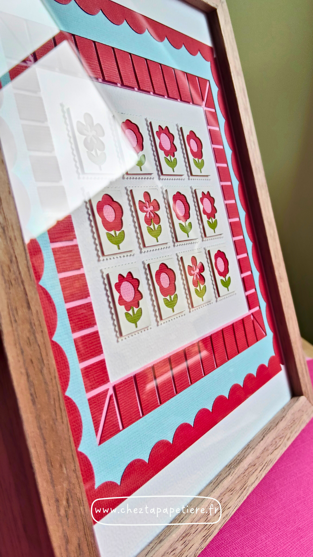 Quatre mini timbres fleurs rouges en papier découpé à la main présentés dans un cadre décoratif